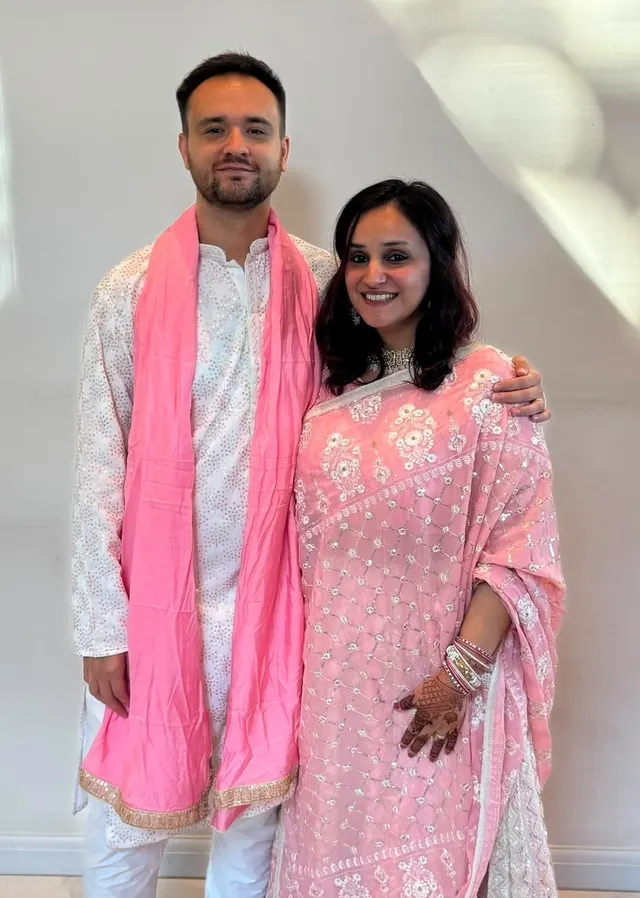 Krishna and Matt in matching pink and white Indian outfits